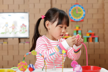 young girl making bead craft at home