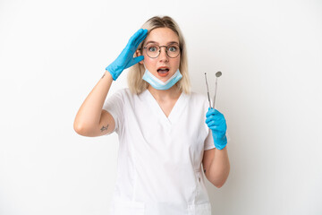 Dentist caucasian woman holding tools isolated on white background with surprise expression