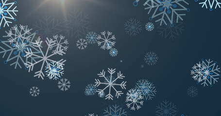 Image of christmas snowflakes falling on blue background