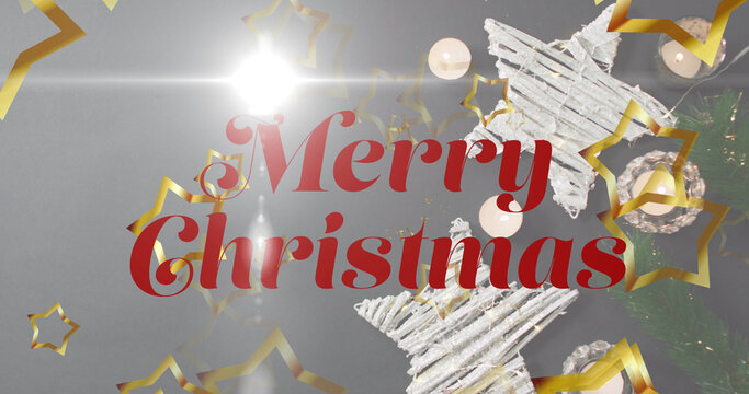 Image of merry christmas text over decorations on grey background