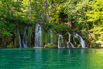 Waterfalls flowing into the crystal water of Lake Plitvice