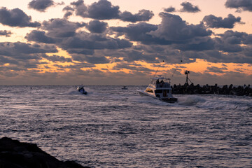 Motor boats heading out of Manasquan inlet at sunrise to go fishing