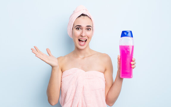 young pretty woman feeling happy and astonished at something unbelievable. shower and shapoo concept