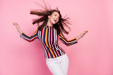 Photo of cute adorable young lady wear striped shirt dancing smiling isolated pink color background