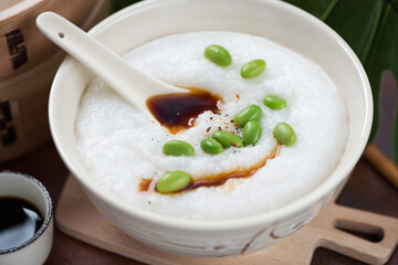Beige bowl with congee or a type of rice porridge eaten in asian countries, selective focus, close-up