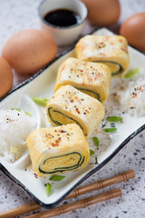 Closeup of sliced tamagoyaki or sweetened japanese egg roll with addition of nori, vertical shot