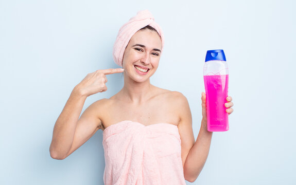 young pretty woman smiling confidently pointing to own broad smile. shower and shapoo concept