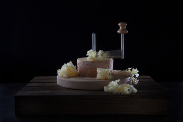 The tete de moine cheese is cut with a special girolle knife. A type of Swiss semi-hard cheese made...