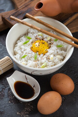 Japanese-style rice and egg bowl, vertical shot on a brown stone background