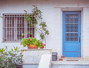 Fototapeta na wymiar traditional house entrance light blue door and flowerpot, Athens Greece