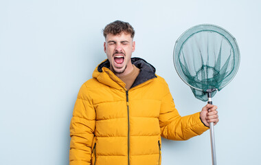 young handsome man shouting aggressively, looking very angry. fisherman concept