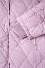 Close-up on lilac puffer jacket texture. Quilted fabric background