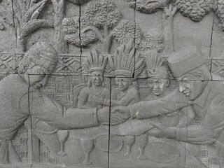 Reliefs of the life of the indigenous people of Kalimantan playing traditional musical instruments on the walls of Central Park, North Penajam Paser Regency