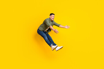 Fototapeta na wymiar Full length body size view of attractive cheerful funny carefree guy jumping having fun isolated over bright yellow color background