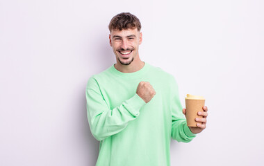 young handsome man feeling happy and facing a challenge or celebrating. take away coffee concept