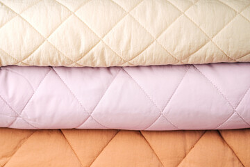 Soft folded blankets. Stack of quilted blankets