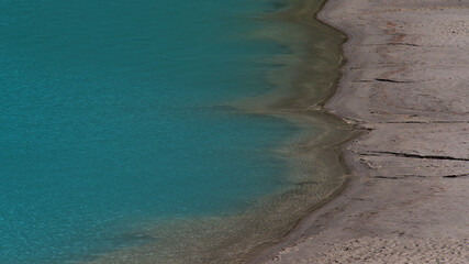 High angle view of the sandy shore of Lake Louise with characteristic turquoise colored water in Banff National Park, Alberta, Canada in the Rockies.