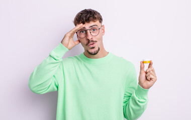 young handsome man looking happy, astonished and surprised. contact lenses