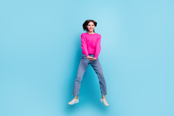 Full length body size view of attractive cheerful girl jumping having fun isolated over bright blue color background