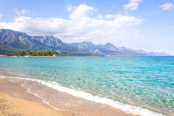 Fototapeta na wymiar Seascape: clear blue sky, turquoise sea and mountains on the shore. Coastline of Kemer, Turkey.