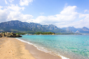 Fototapeta na wymiar Seascape: clear blue sky, turquoise sea and mountains on the shore. Coastline of Kemer, Turkey.