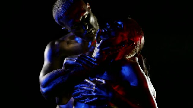 sexy woman is enjoying sensual pleasure in embrace of beloved man, body art by golden dye