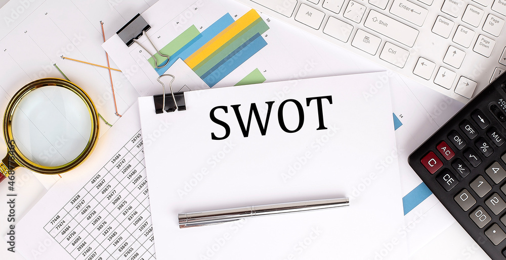 Poster swot text on the white paper on the light background with charts paper ,keyboard and calculator