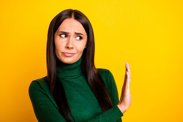 Photo of young unhappy upset sad woman showing stop no sign wear green turtleneck isolated on yellow color background