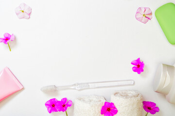 Fototapeta na wymiar Spa white background pink flowers and a bottle of shampoo, soap white towels rolls. Body care, hygiene and cleanliness concept