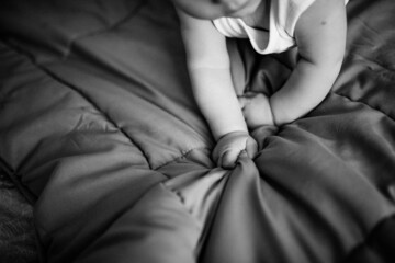 Baby hands. The child is lying on the bed.