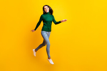 Fototapeta na wymiar Full size photo of cheerful nice pretty young woman jump up walk smile isolated on yellow color background