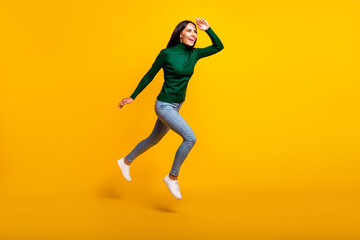 Fototapeta na wymiar Full body profile side photo of brunette lady wear green sweater jeans look empty space jump run isolated on yellow color background