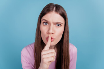 Fototapeta premium Closeup headshot photo of cute young girl finger cover lips shh keep secret confidential isolated over blue color background