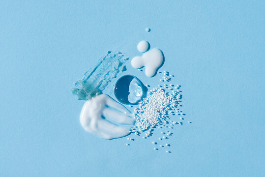 Cosmetic smears and drops. Appearance of the texture of the cream, oil and granules on a blue background. Natural skincare products. Beauty concept for face and body care - Powered by Adobe