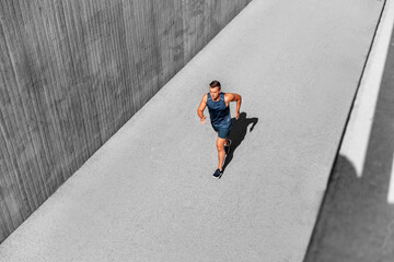 fitness, sport and healthy lifestyle concept - young man running outdoors