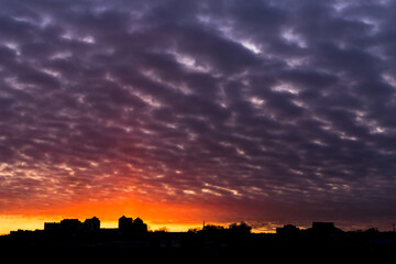 Amazing colorful sunset with city silhouette. Sky background.