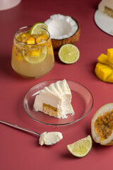 Minimalistic mousse cake with violet white on a pink background. Mousse cake with tropical fruit flavors - mango, coconut, passionfruit, lime.