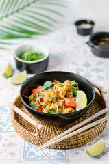 Noodles with meatballs, cilantro, curry sauce, cherry tomatoes and a slice of lime.