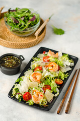 Asian salad with prawns, lettuce, cherry tomatoes, pomelo and red onion.