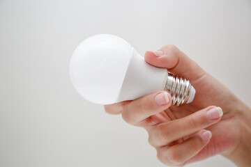 Lampada led de energia branca na mão de uma pessoa segurando.