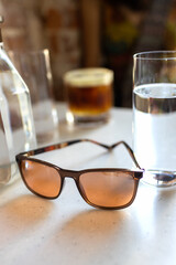 Sunglasses, glass of water and coffee on a table in a cafe