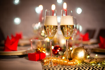 romantic two cup of champagne on a christmas holiday festive party table with red and gold shiny decoration