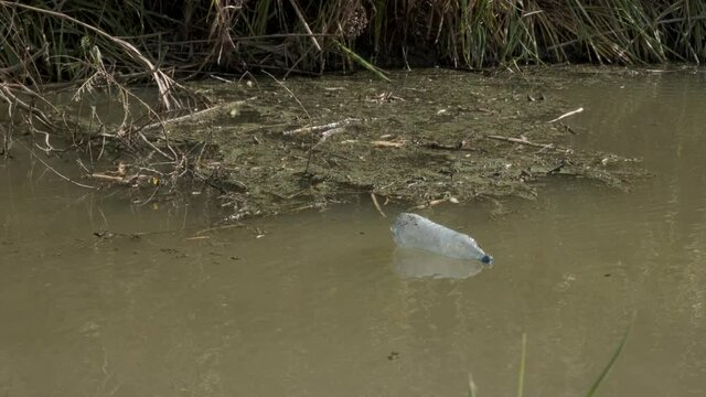 Plastic bottles swim on current in the coastal area in the delta Danube river. Plastic pollution