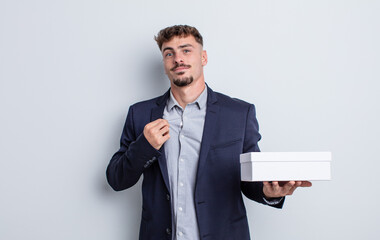 young handsome man looking arrogant, successful, positive and proud. white box package