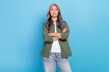 Photo of strict elder white hairdo lady crossed arms wear khaki shirt jeans isolated on blue color...
