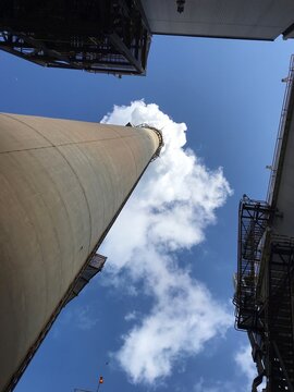 A high chimney that emits steam from a thermal power plant seen from directly below.