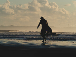 surfer on the beach at sunset