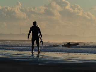 surfer on the beach at sunset