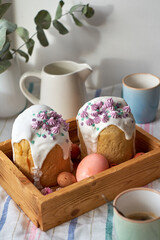 Traditional Easter cake with glaze and decorated mini meringue. White background, side view, pink eggs, pink flowers