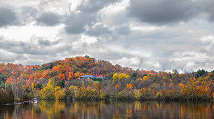 Fall colours along the Gatineau river reflected in water, Quebec, Canada